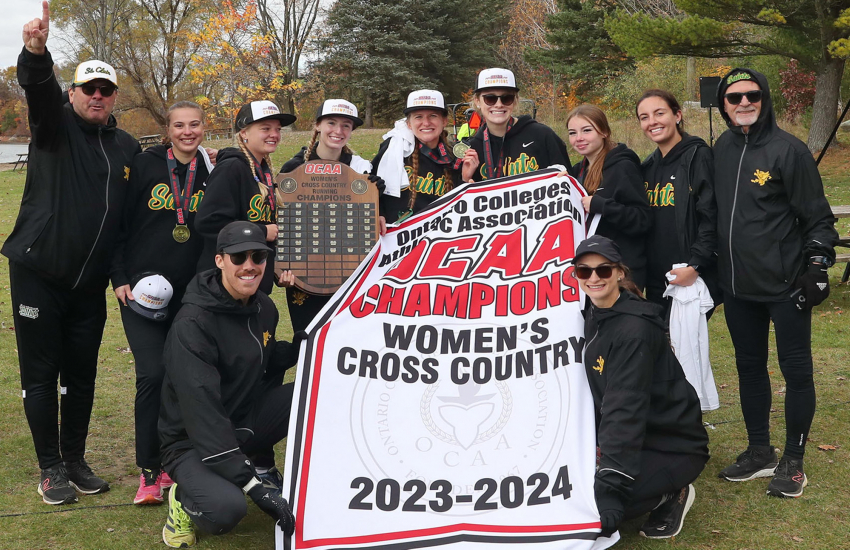 Womens Cross Country team with champion banner