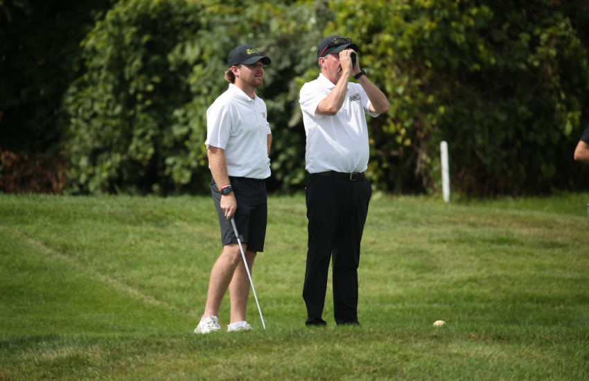 Kevin Corriveau using range finder on course with golfer