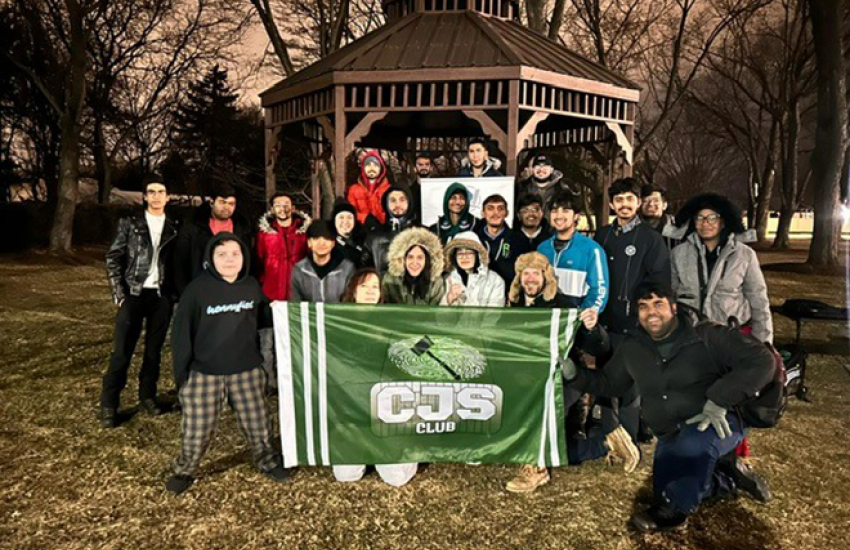 Student group photo at gazebo with CJS banner