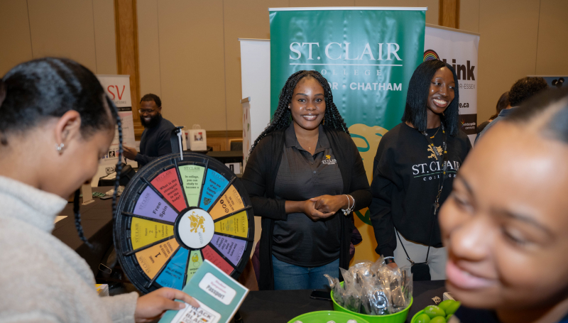 St. Clair representatives and attendees near spin wheel
